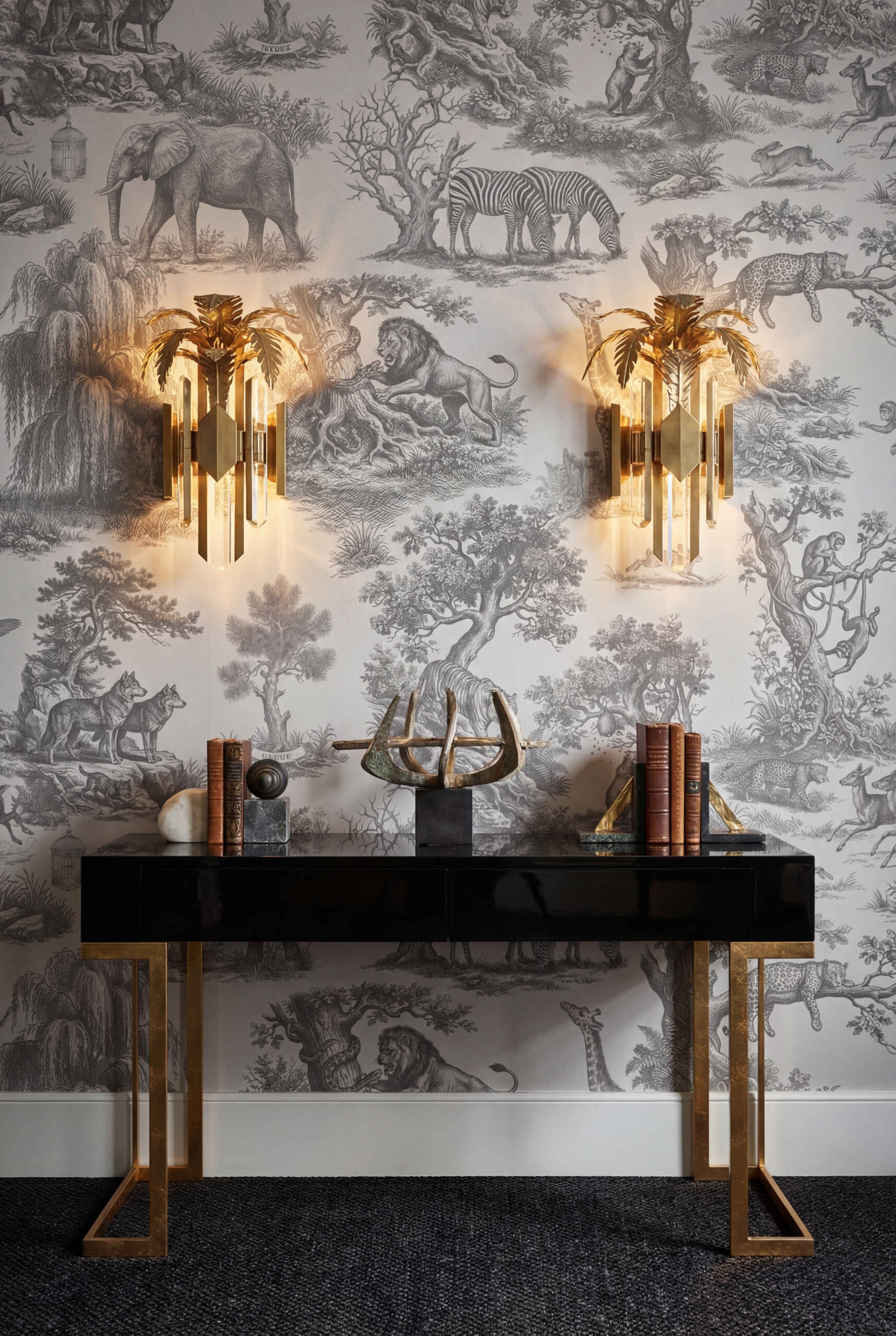Musee | Wilderness Toile Wallpaper Classic Toile de Jouy wallpaper by Musee featuring intricate engravings of wild animals like giraffes, elephants, lions, and monkeys amidst trees and nature.
