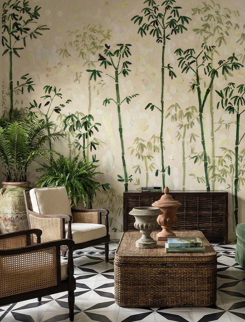 Artistic painterly bamboo custom wallpaper mural behind a classic rattan sitting area. "Whispering Bamboo" premium tropical Chinoiserie wall design in Dubai.